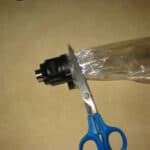 Scissors cutting excess plastic bag off new Volcano vaporizer balloon near valve
